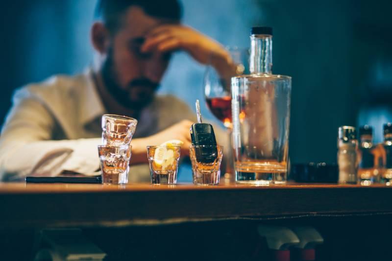 Mężczyzna topiący smutki w alkoholu